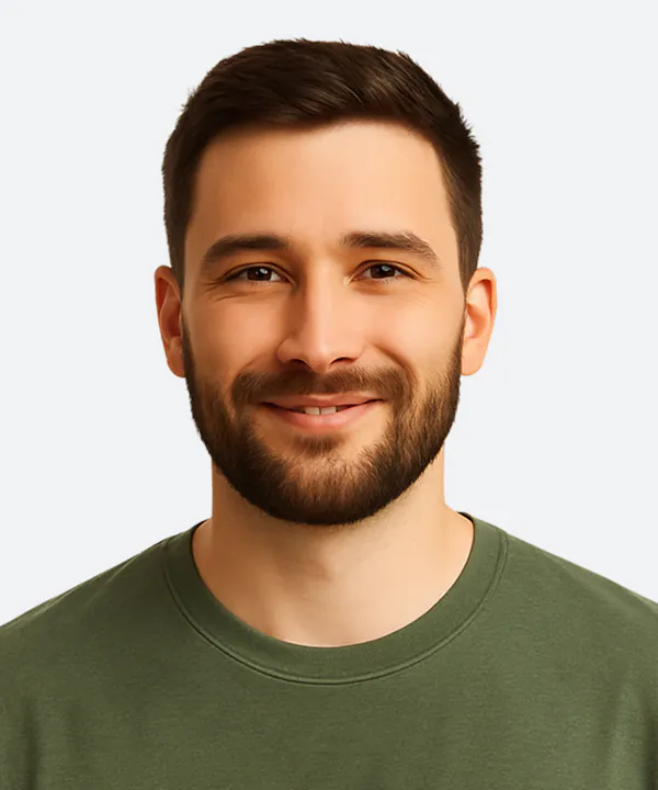Man with dark hair and beard wearing an olive green t-shirt against a light gray background.