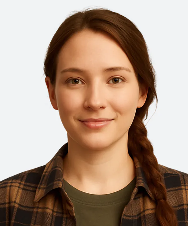 Woman with long brown hair wearing a plaid shirt over a green shirt, against a white background.