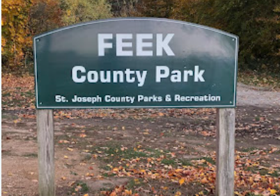 Feek County Park sign for St. Joseph County Parks & Recreation among autumn foliage.