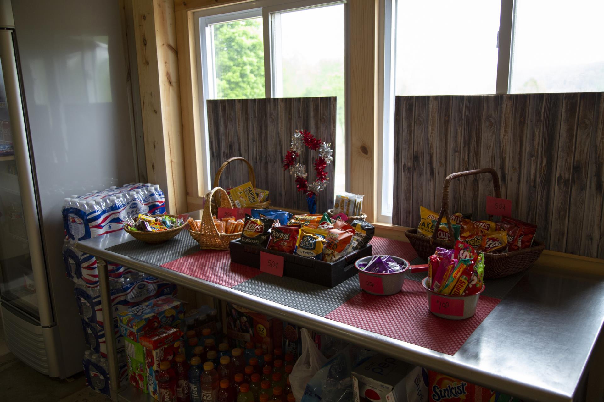 Counter display with snack baskets, beverages, and holiday decorations including wreaths and red gift boxes.