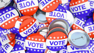 Red, white, and blue "VOTE" buttons with stars scattered in a pile.